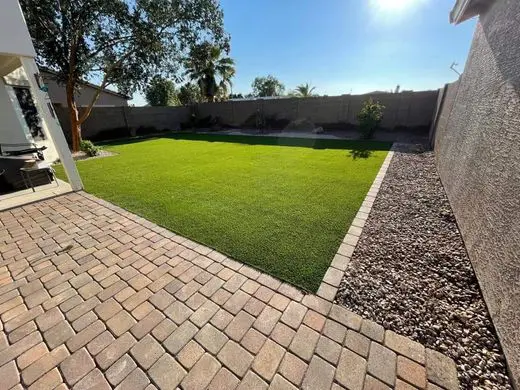 backyard artificial turf in Coachella Valley with paved brick borders